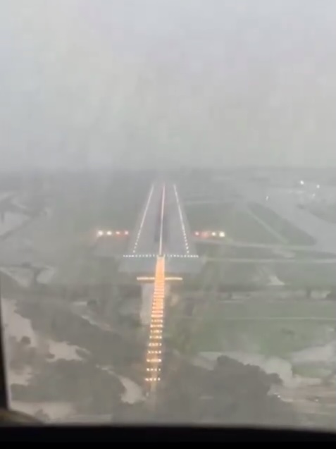 a plane is taking off from an airport runway in the rain .