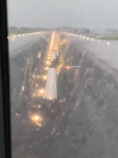 a plane is taking off from an airport runway in the rain .