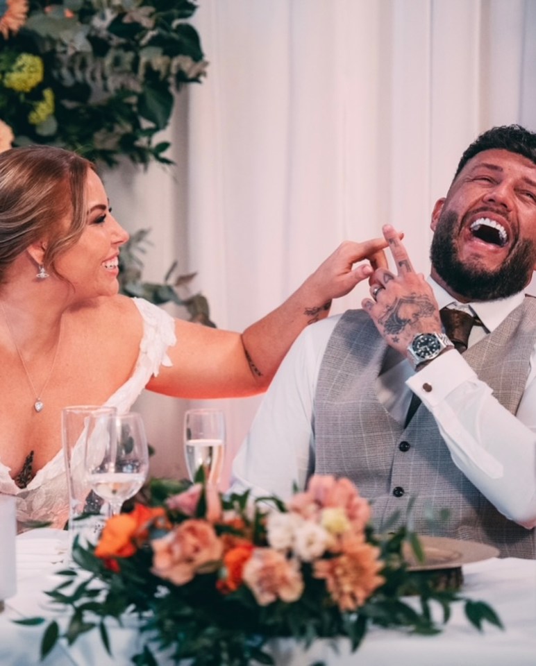 a bride and groom are laughing at their wedding reception