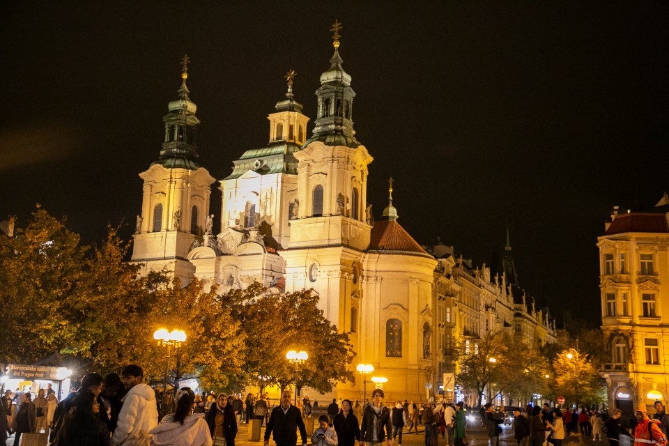 a crowd of people walking in front of a church at night