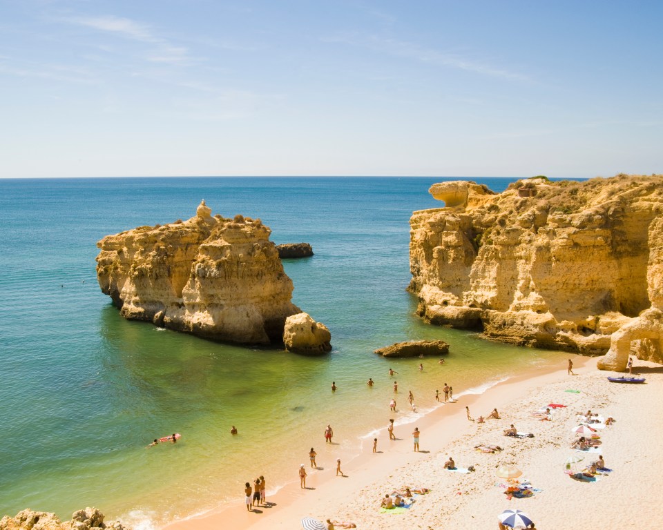 a beach with a large rock in the middle of it