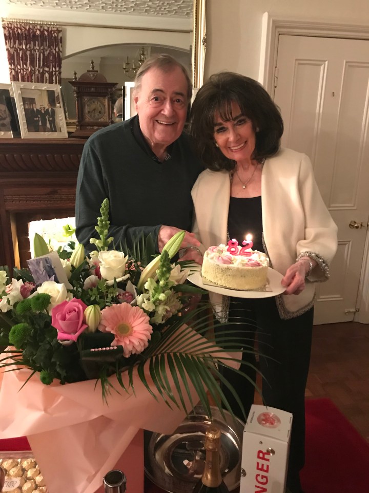 a woman is holding a cake with the number 50 on it