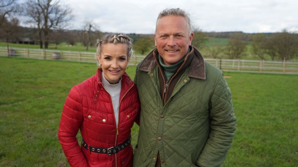 a man and a woman are posing for a picture in a field