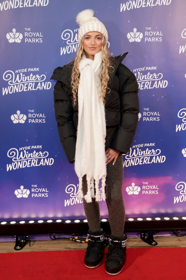 a woman stands on a red carpet at the hyde park winter wonderland