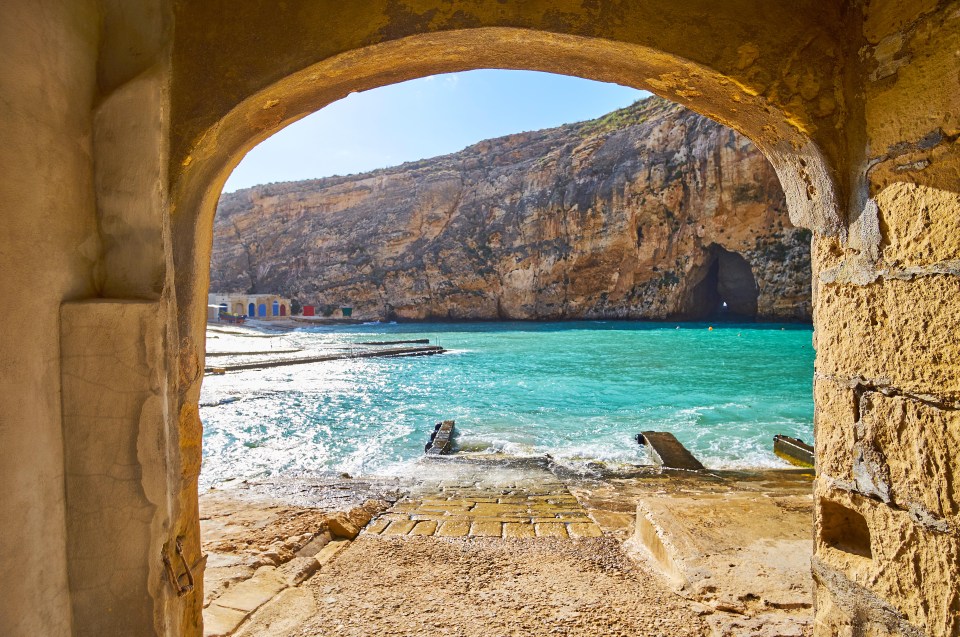 a view of the ocean through a stone archway