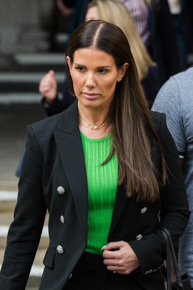 a woman wearing a green top and a black jacket