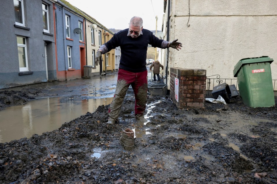 A 75-year-old resident tries to move through mud in Cwmtillery, South Wales, after a landslide