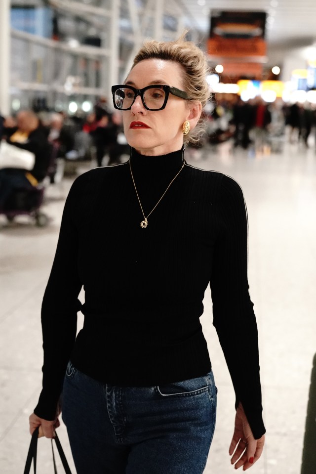 a woman wearing glasses and a black turtleneck