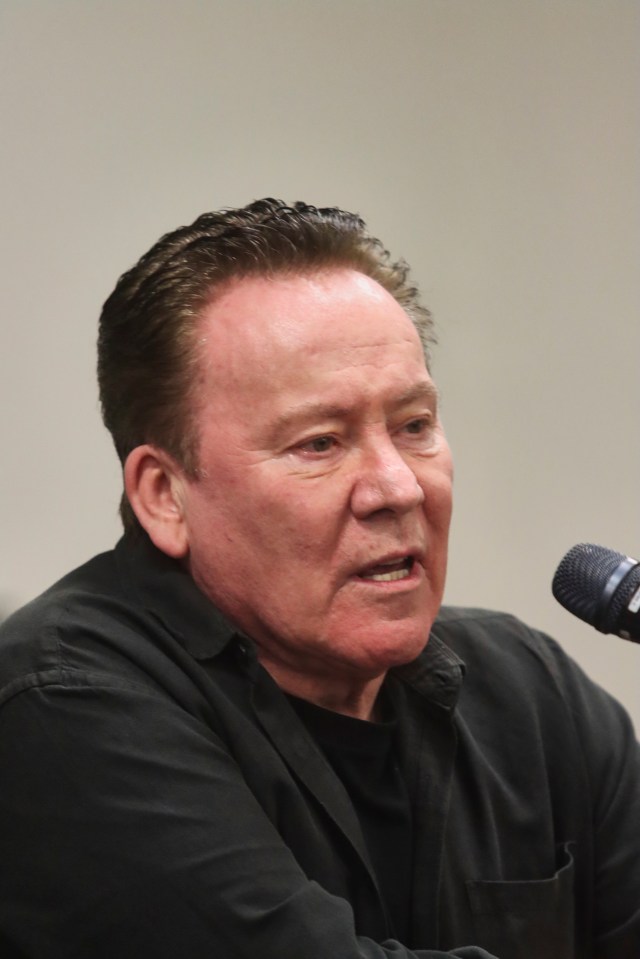 a man in a black shirt is speaking into a sennheiser microphone