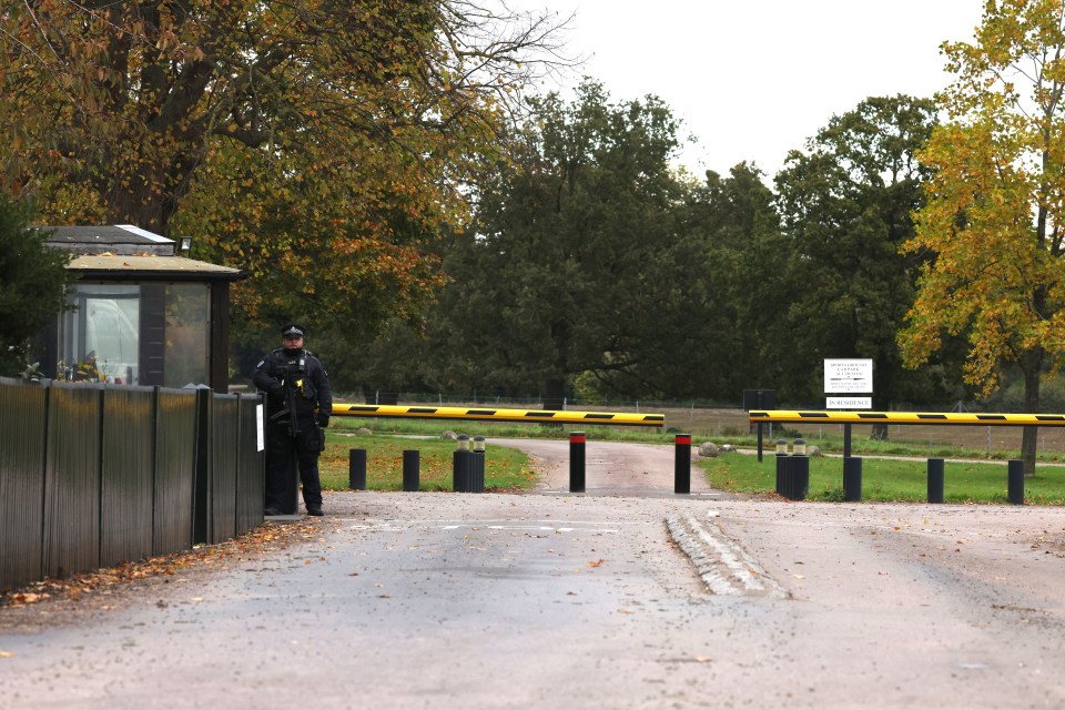 a police officer stands at the gate of a park