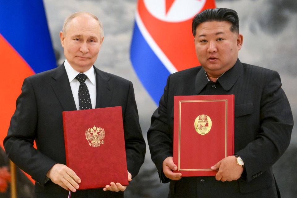 two men standing next to each other holding a red book that says ' russia ' on it