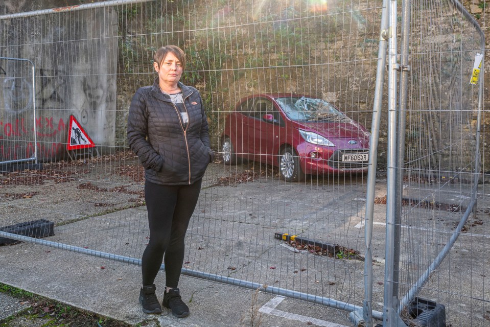 Sally Taylor beside the crushed car, which has now been moved