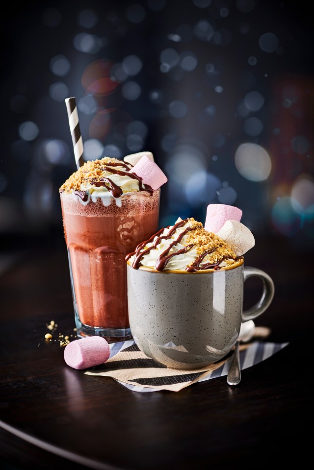 two cups of hot chocolate with whipped cream and marshmallows