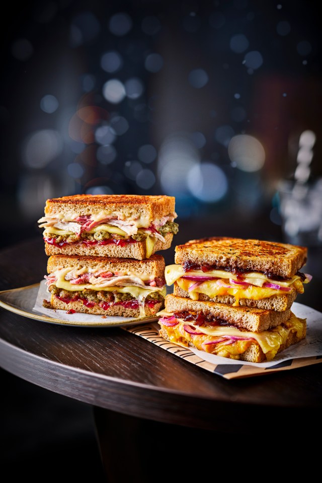 two sandwiches are stacked on top of each other on a table