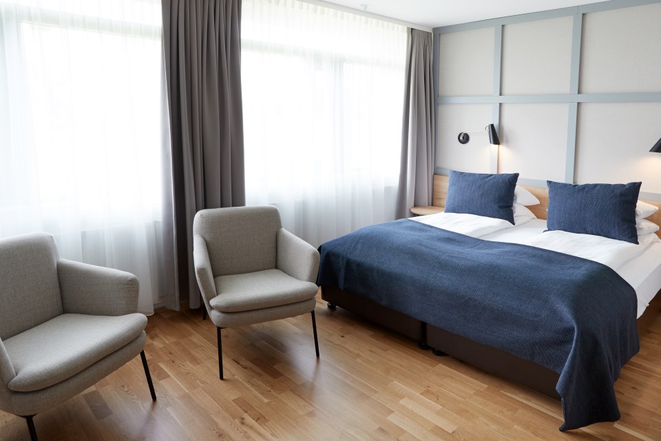 a hotel room with a bed and two chairs