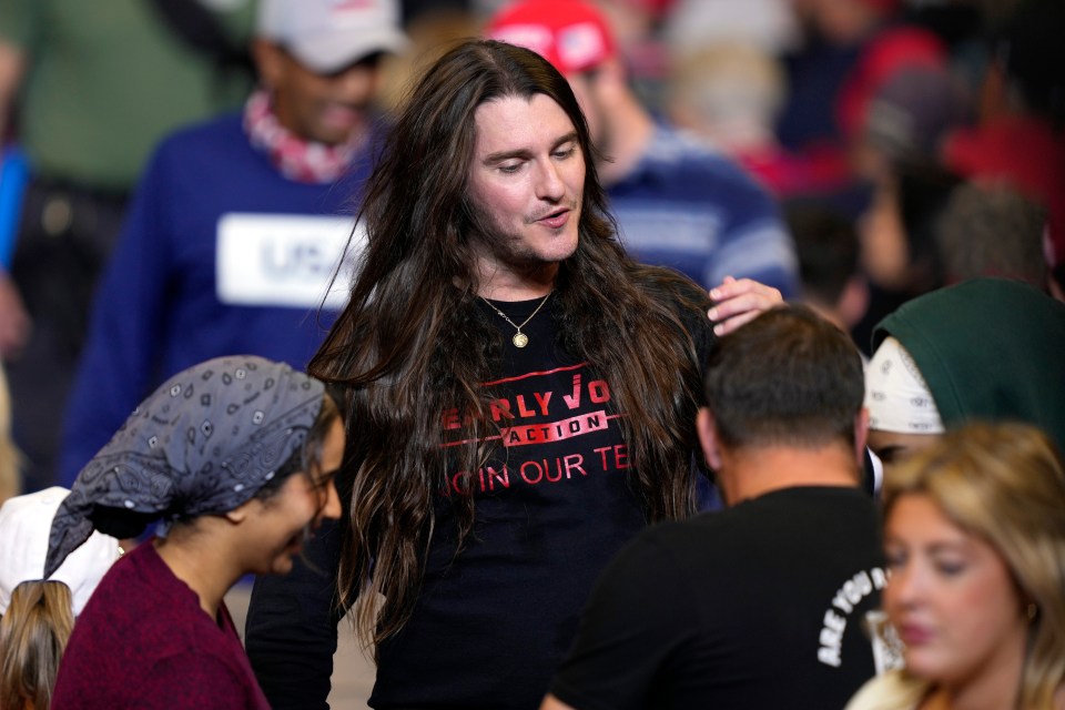 a man with long hair is wearing an early voting action shirt