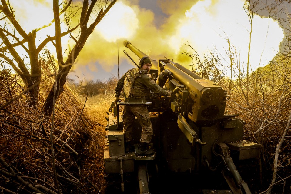 two soldiers are firing a cannon with smoke coming out of it