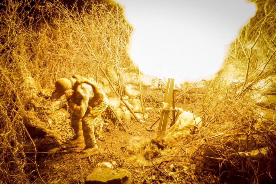 A Ukrainian soldier fires a 120-mm mortar towards Russian troops