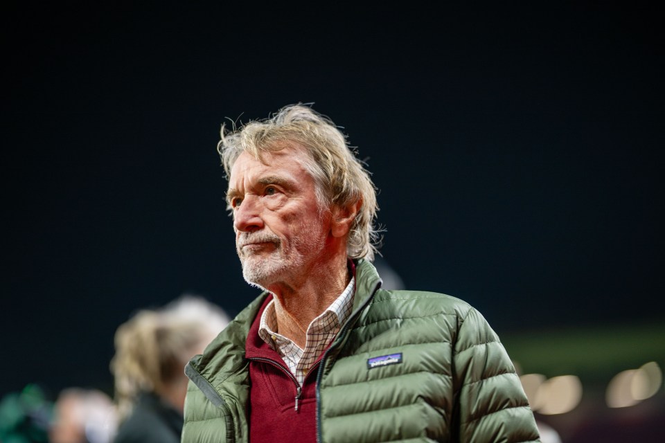 a man wearing a green patagonia jacket stands in the dark