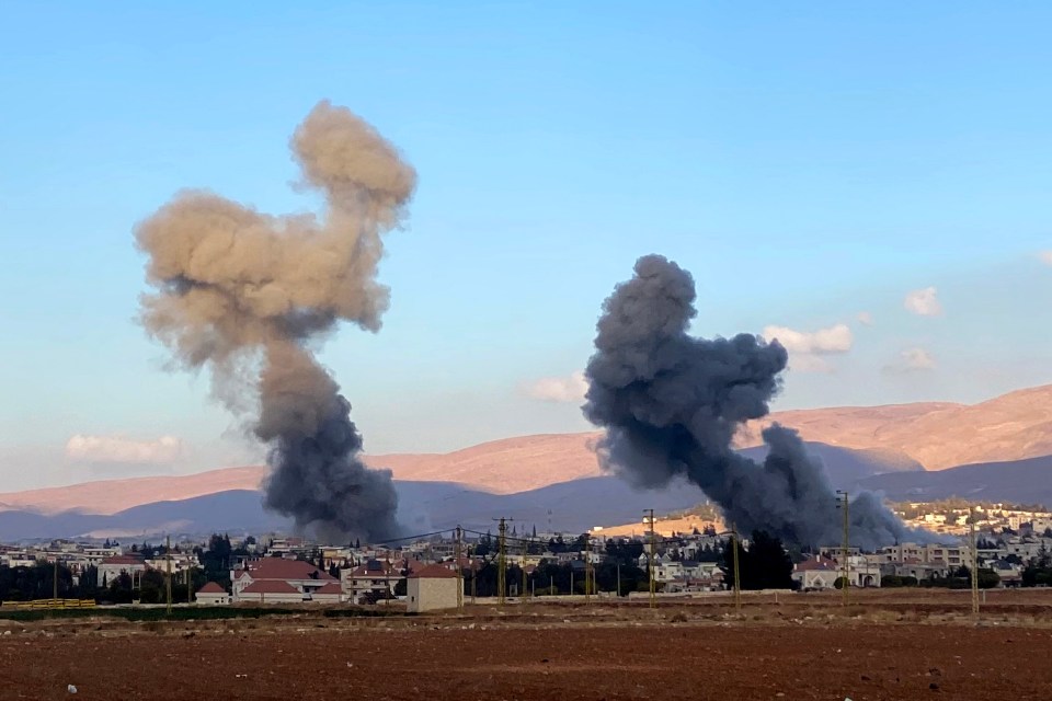 smoke coming out of a building with mountains in the background