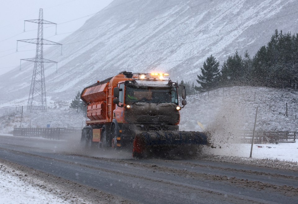 a snow plow is driving down a snowy road