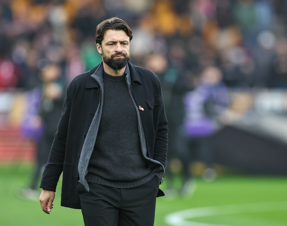 a man with a beard is walking on a soccer field