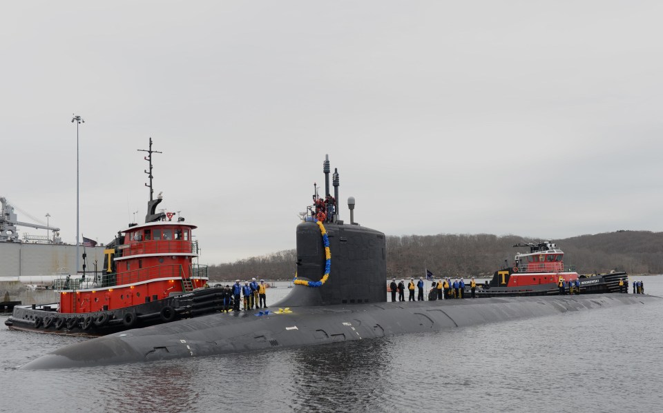 a submarine is being towed by a tug boat