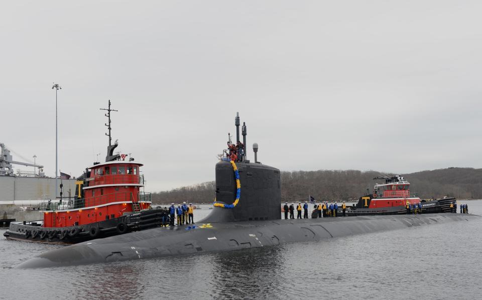 Sailors stand on top of a USS Virginia sub