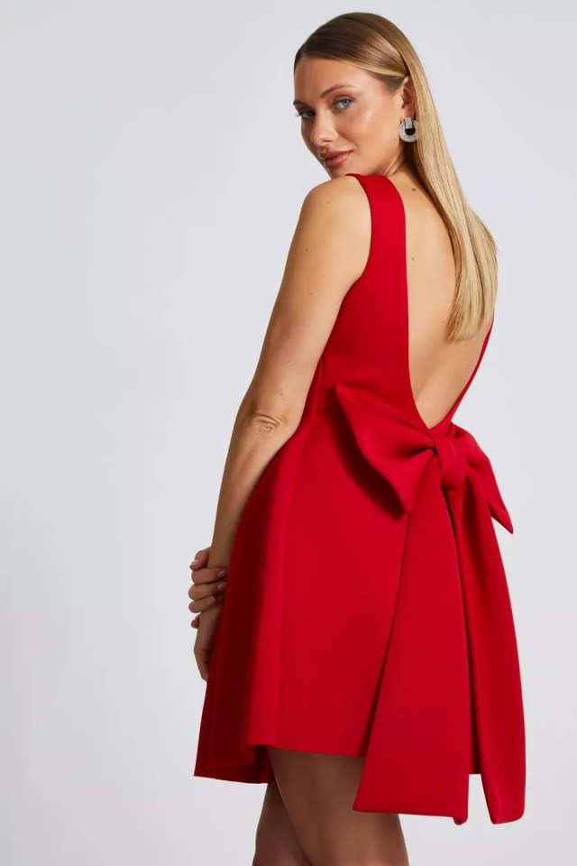 a woman in a red dress with a bow on the back