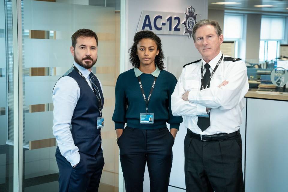 three police officers are standing in front of a sign that says ac-12