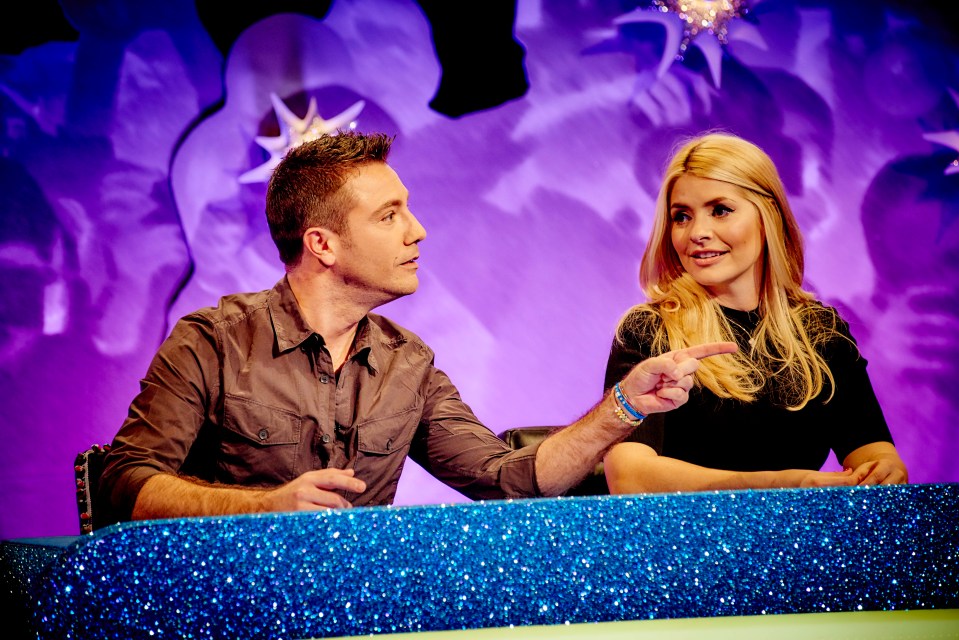 a man and a woman are sitting at a table and the woman is pointing