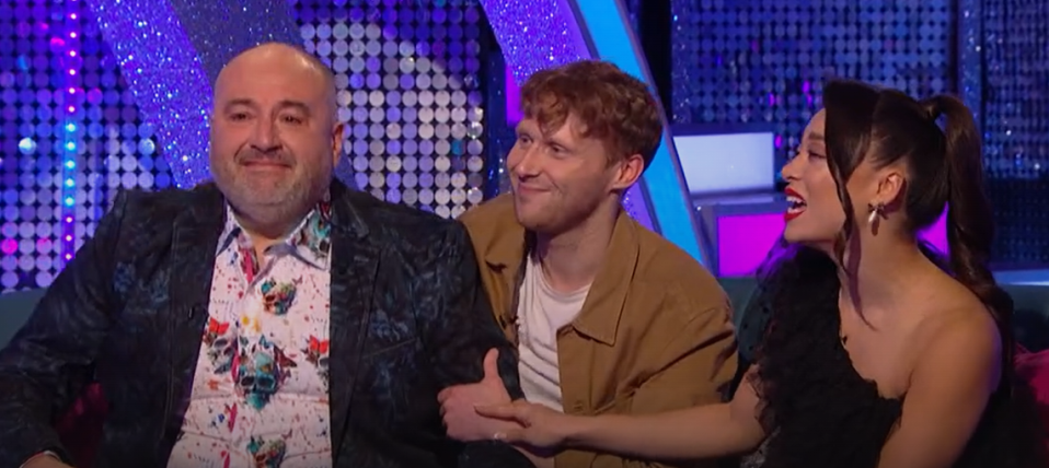 two men and a woman are sitting next to each other and smiling