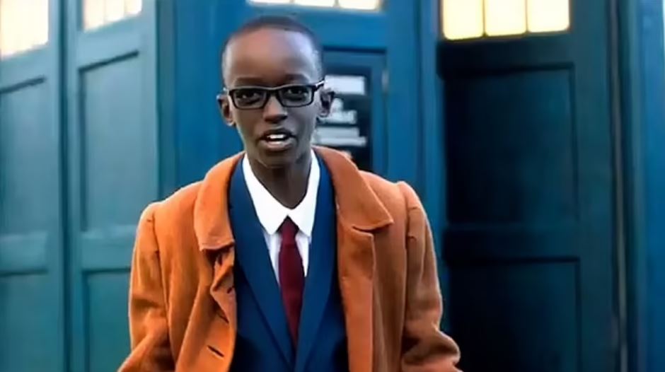 a young man in a suit and tie is standing in front of a blue door .