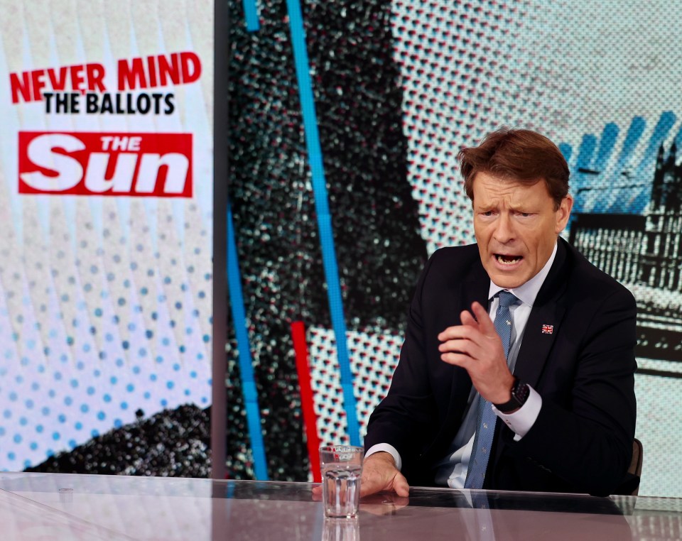 a man sitting in front of a sign that says never mind the ballots