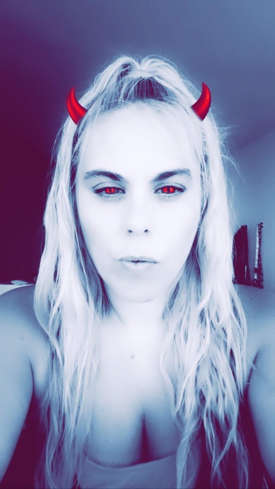 a woman with devil horns on her head takes a selfie