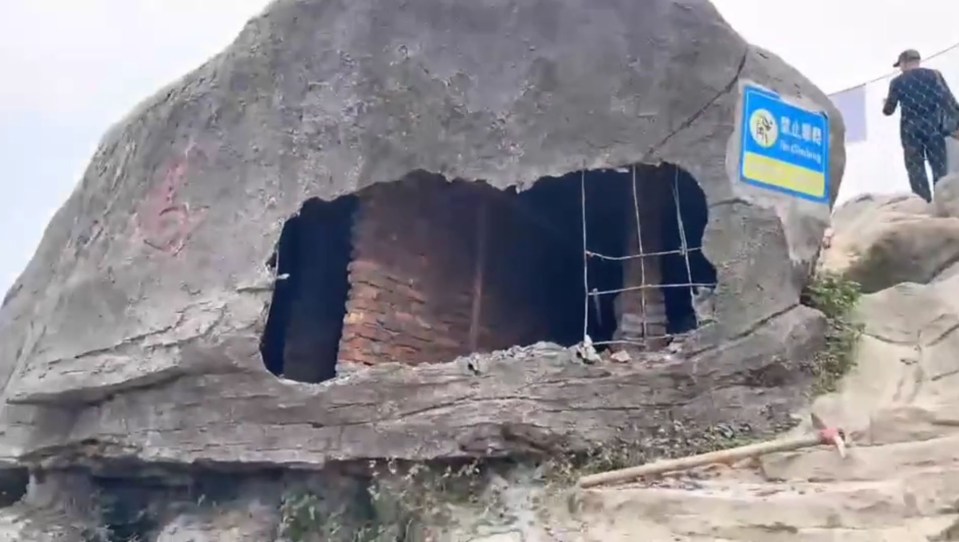 a large rock with a hole in it and a sign that says no littering