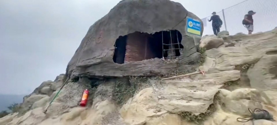 a large rock with a hole in it and a sign that says ' a ' on it