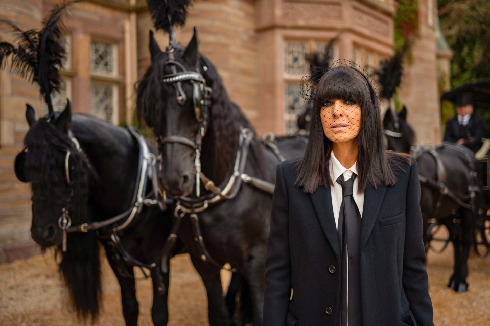 a woman in a veil stands in front of a horse drawn carriage