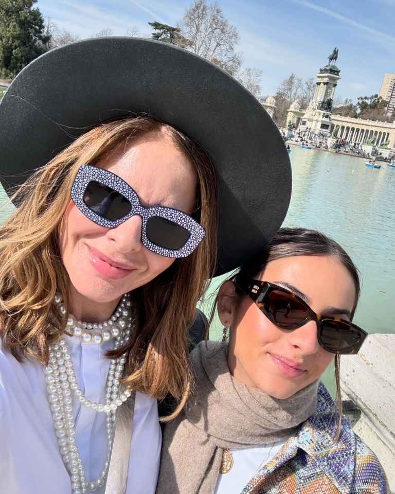 two women wearing sunglasses and pearls pose for a picture