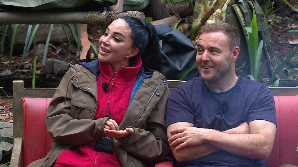 a man and a woman are sitting next to each other on a red bench