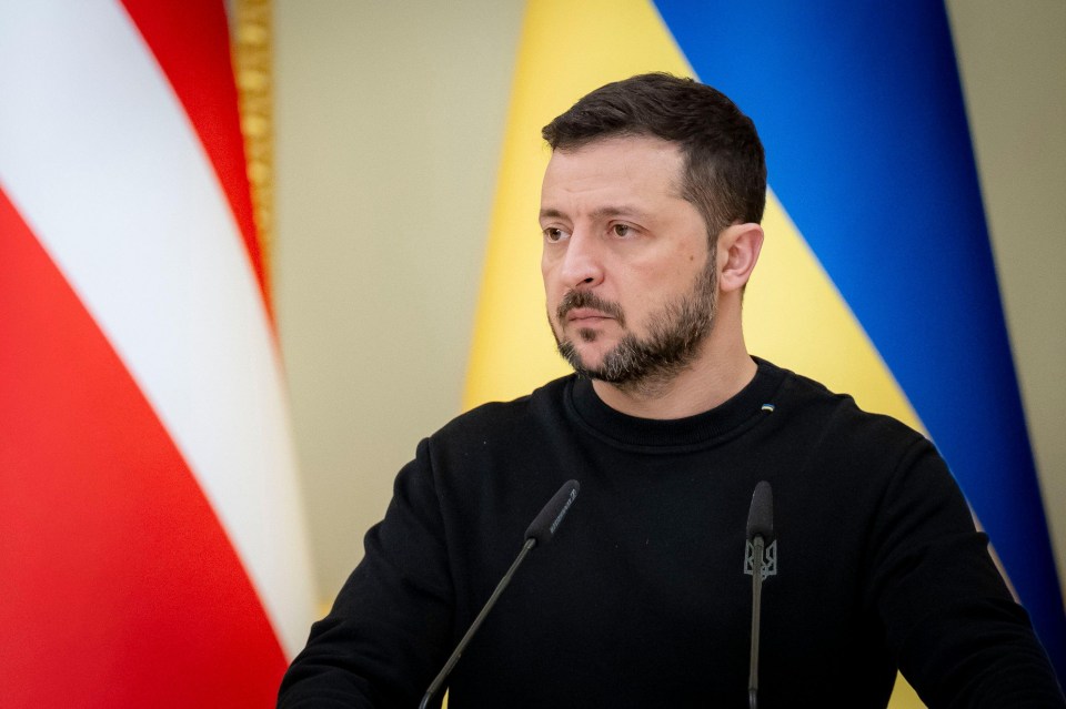 a man with a beard stands in front of two microphones