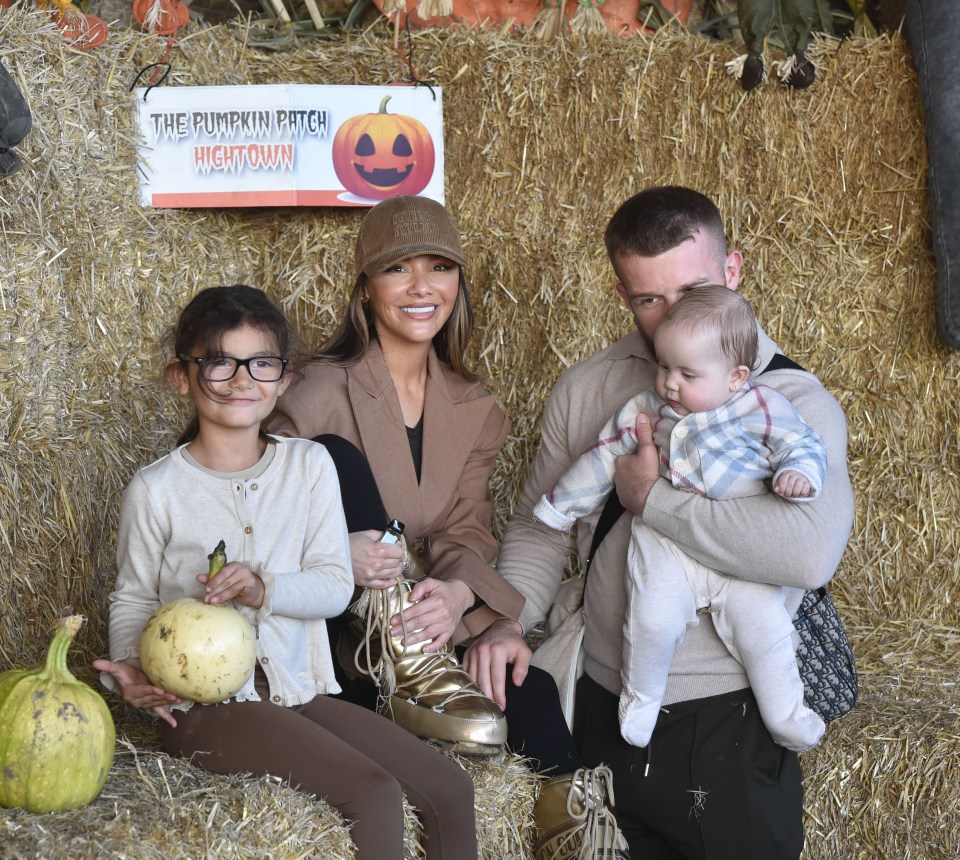 a family poses in front of a sign that says the pumpkin patch hightown