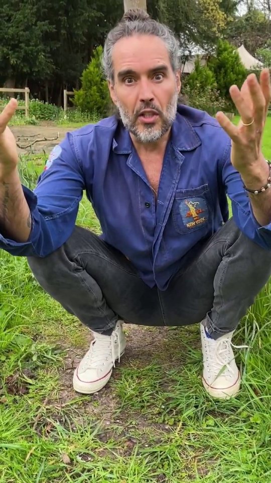 a man in a blue shirt that says new york squatting in the grass