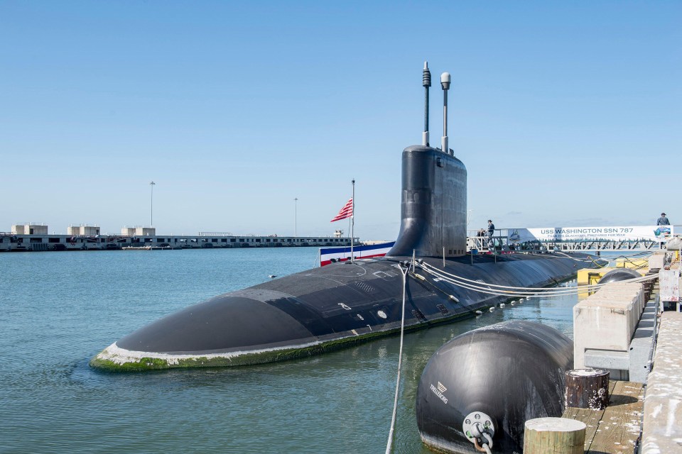 a submarine is docked next to a sign that says uss washington ssn 787