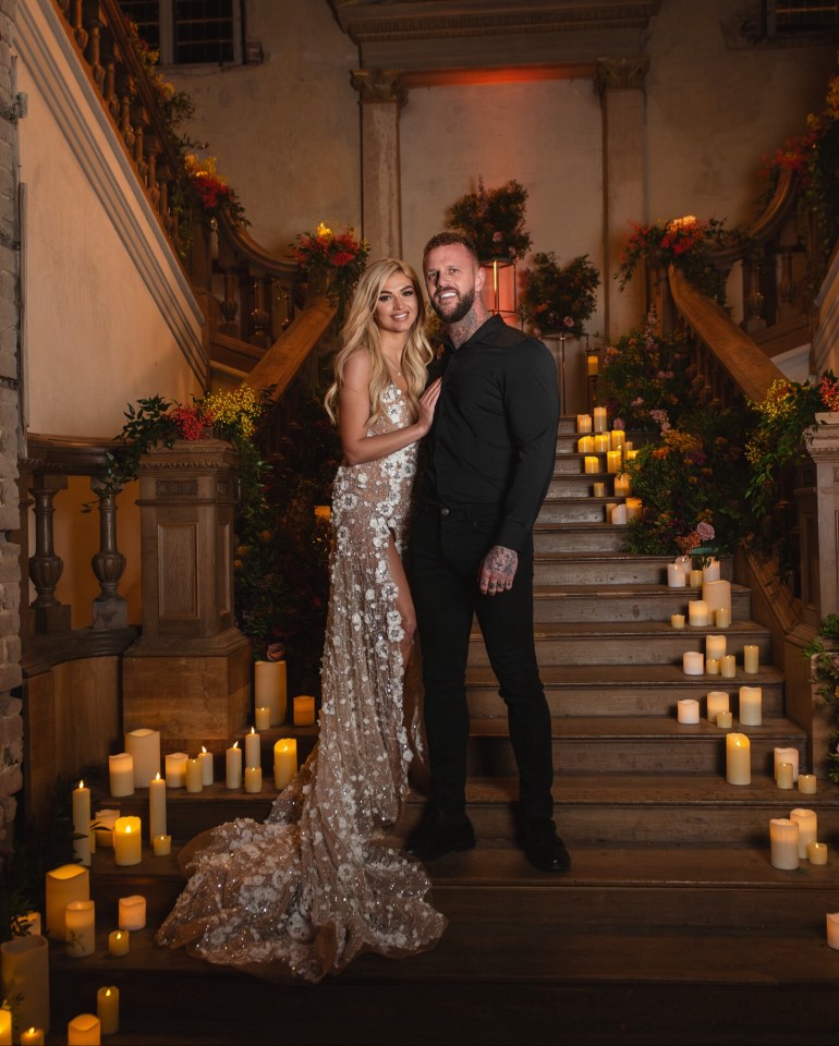 a man and a woman standing on a set of stairs surrounded by candles