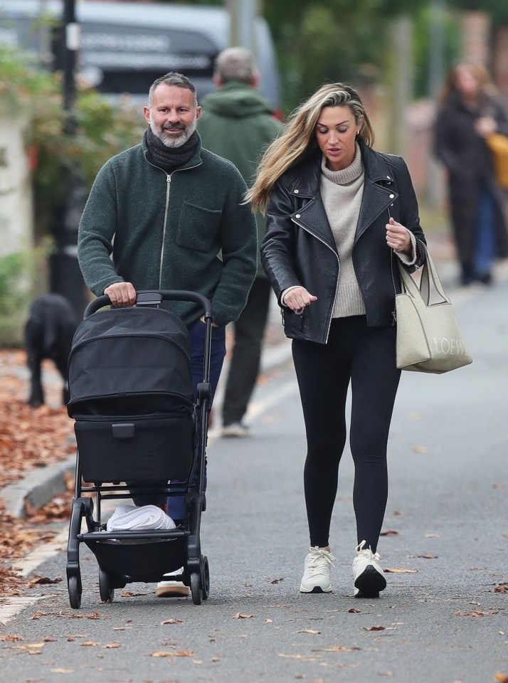 a man pushing a stroller with a woman holding a loewe bag