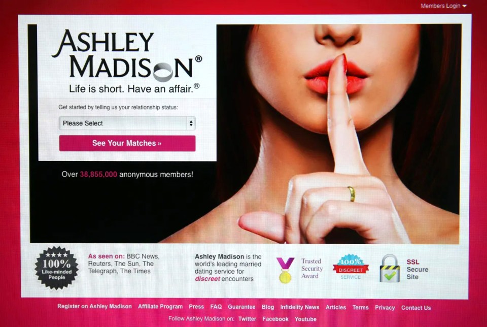 a person is typing on a laptop with an advertisement for ashley madison on the screen