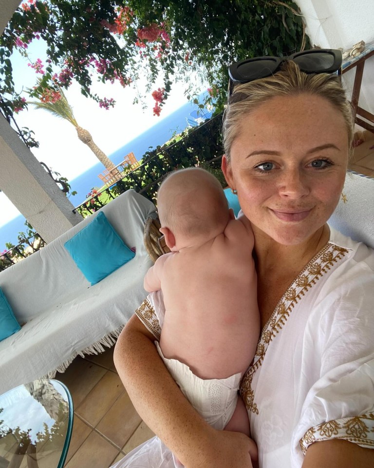 a woman wearing sunglasses holds a baby in her arms