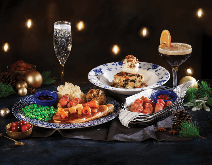 a table topped with plates of food and a glass of wine