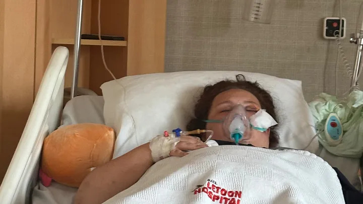 a woman is laying in a hospital bed with an oxygen mask on her face